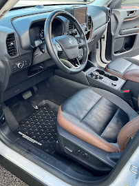 SUV interior with clean leather seats, mats, and dash