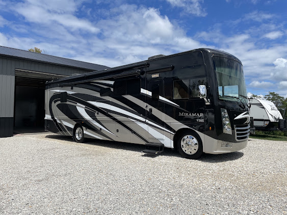 Large Class A motorhome detailed and gleaming outside a garage