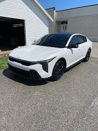 White sedan with black wheels finished and gleaming in a driveway